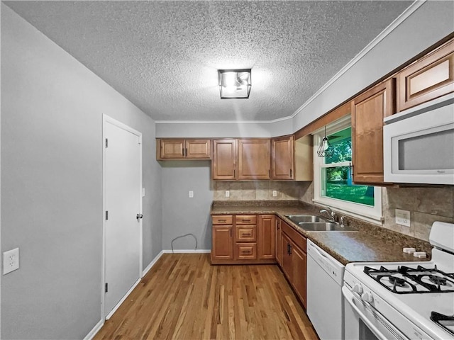 11709 Fremont Ave, Kansas City, MO 64134 - kitchen featuring white appliances, a sink, brown cabinetry, a textured ceiling, and light wood-style floors