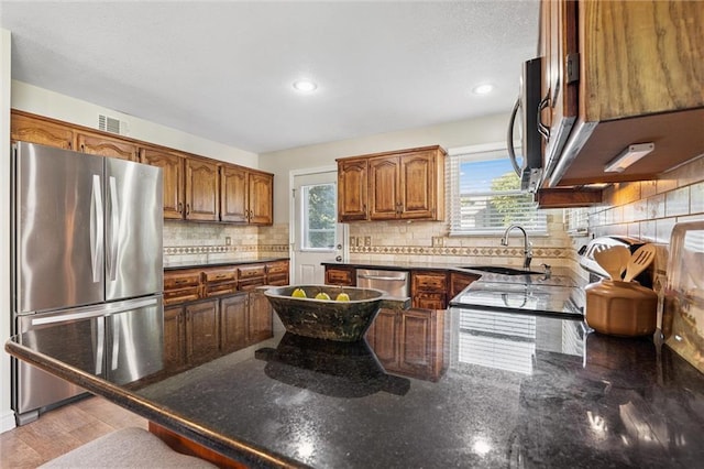 21607 W 51st St, Shawnee, KS 66226 - kitchen featuring appliances with stainless steel finishes, healthy amount of natural light, a peninsula, decorative backsplash, and recessed lighting