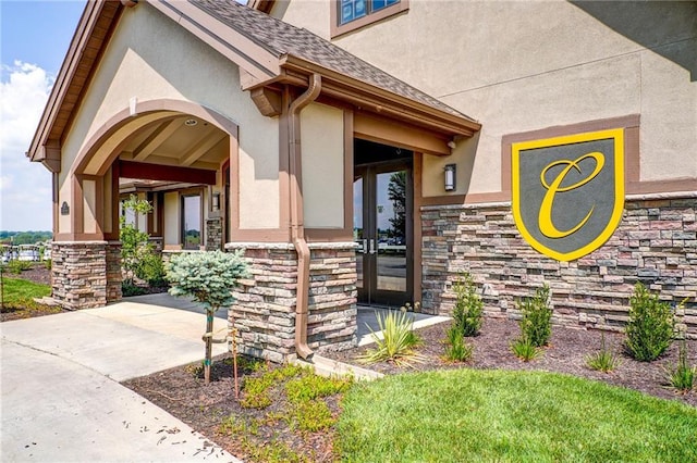 600 Mayfair Ct, Raymore, MO 64083 - property entrance featuring stucco siding, stone siding, and a shingled roof