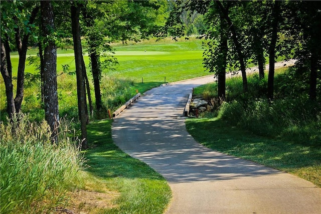 600 Mayfair Ct, Raymore, MO 64083 - surrounding community with golf course view and view of wooded area