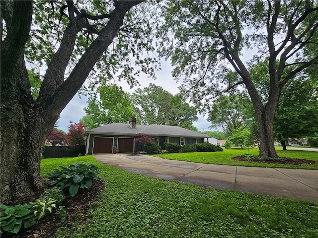 11306 E 45th St, Kansas City, MO 64133 - single story home with a garage, concrete driveway, and a chimney