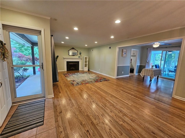11306 E 45th St, Kansas City, MO 64133 - unfurnished living room with ornamental molding, light wood-style flooring, recessed lighting, baseboards, and a fireplace