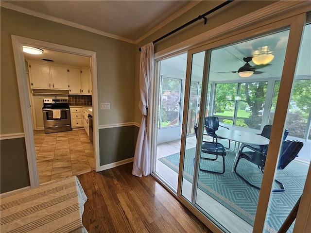 11306 E 45th St, Kansas City, MO 64133 - doorway to outside with baseboards, ornamental molding, ceiling fan, and light wood-type flooring