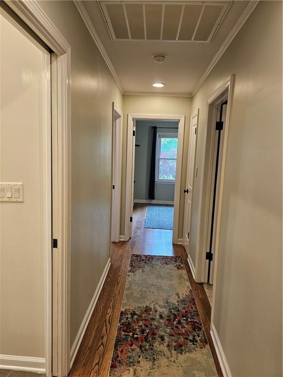 11306 E 45th St, Kansas City, MO 64133 - corridor with dark wood finished floors, baseboards, and ornamental molding