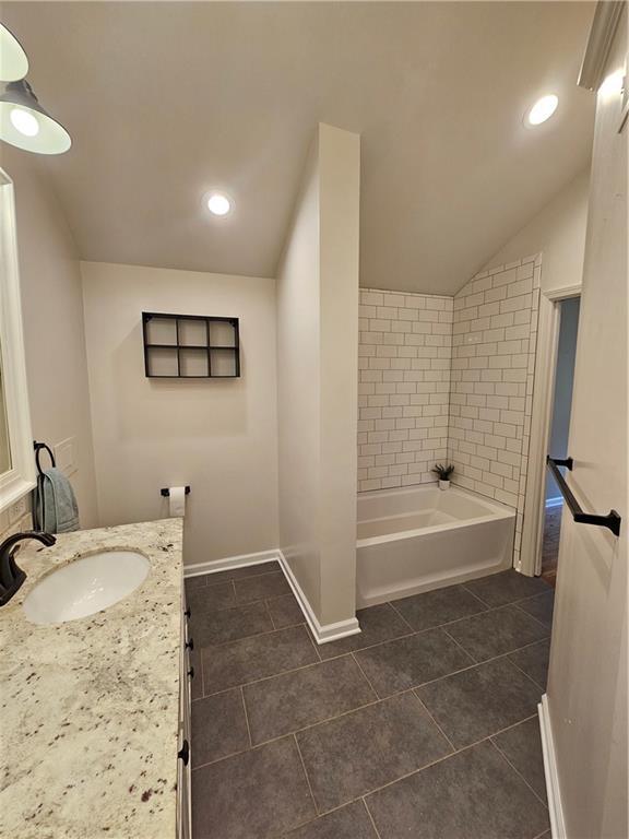 11306 E 45th St, Kansas City, MO 64133 - bathroom with vanity, tile patterned flooring, lofted ceiling, baseboards, and recessed lighting