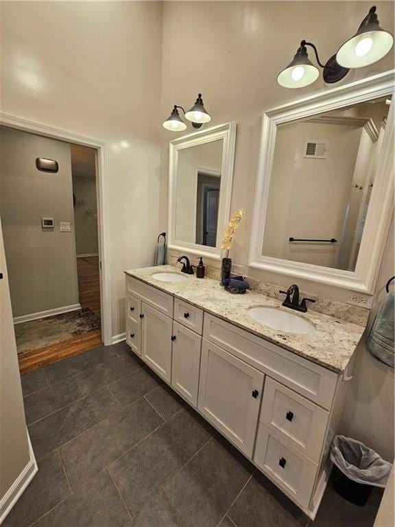 11306 E 45th St, Kansas City, MO 64133 - full bath with double vanity, tile patterned flooring, baseboards, and a towering ceiling