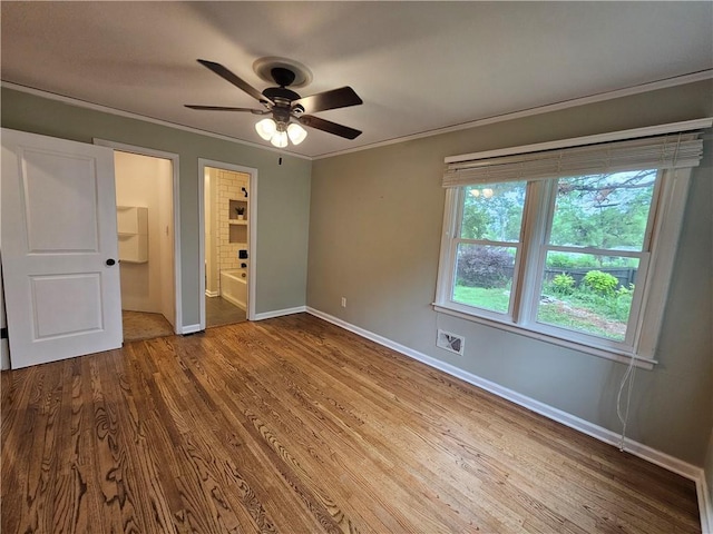 11306 E 45th St, Kansas City, MO 64133 - unfurnished bedroom featuring baseboards, wood finished floors, crown molding, ensuite bath, and ceiling fan
