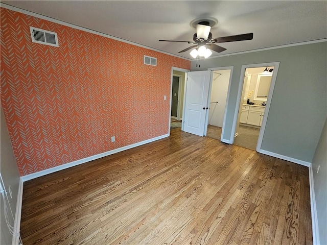 11306 E 45th St, Kansas City, MO 64133 - unfurnished bedroom with wood finished floors, ornamental molding, wallpapered walls, baseboards, and ceiling fan