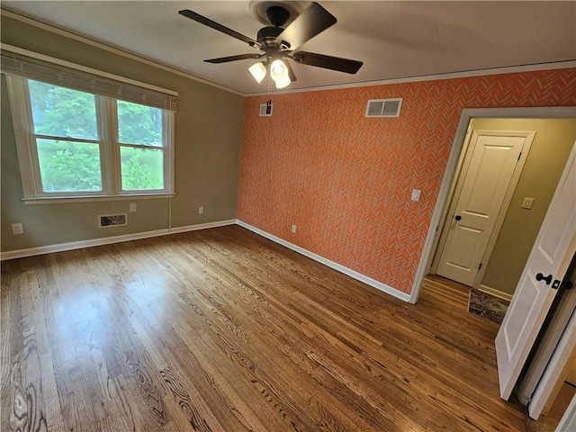 11306 E 45th St, Kansas City, MO 64133 - unfurnished room featuring crown molding, baseboards, a ceiling fan, wood finished floors, and wallpapered walls