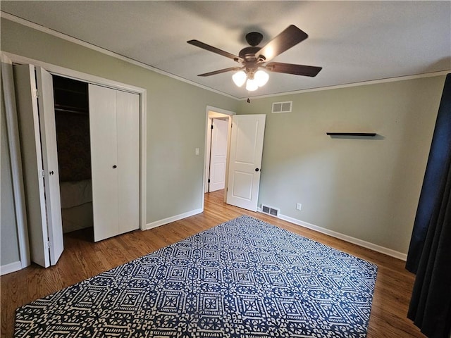 11306 E 45th St, Kansas City, MO 64133 - unfurnished bedroom with wood finished floors, baseboards, ornamental molding, a closet, and ceiling fan