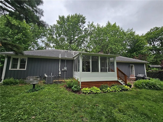 11306 E 45th St, Kansas City, MO 64133 - back of house featuring central air condition unit, a sunroom, and board and batten siding