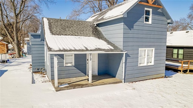 212 S Delaware St, Tonganoxie, KS 66086 - snow covered rear of property featuring a deck and a shingled roof