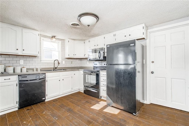 212 S Delaware St, Tonganoxie, KS 66086 - kitchen featuring black appliances, a sink, white cabinets, dark wood-type flooring, and tasteful backsplash