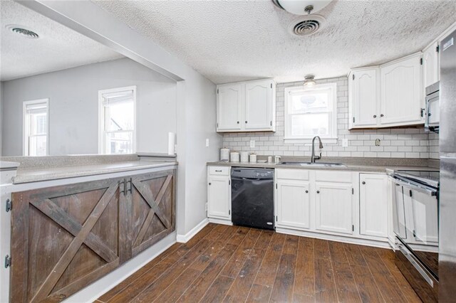212 S Delaware St, Tonganoxie, KS 66086 - kitchen with black dishwasher, a sink, electric range oven, white cabinets, and backsplash