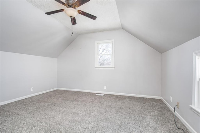 212 S Delaware St, Tonganoxie, KS 66086 - bonus room with carpet, vaulted ceiling, baseboards, ceiling fan, and a textured ceiling