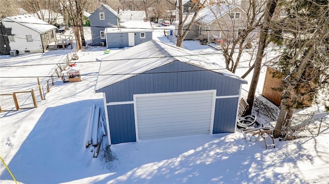 212 S Delaware St, Tonganoxie, KS 66086 - snow covered garage featuring a garage and a residential view