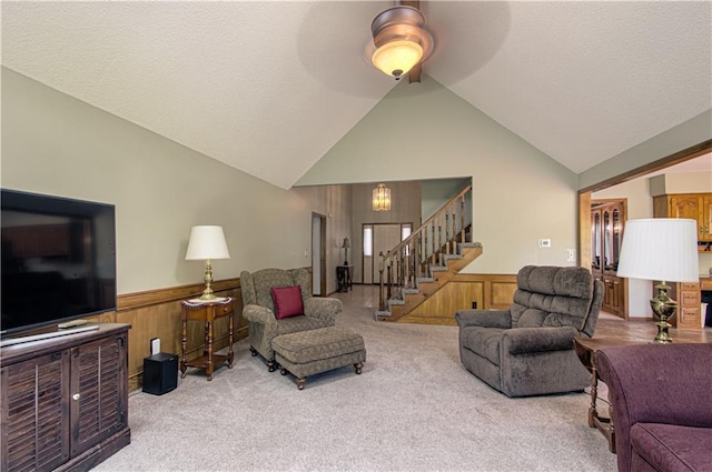 17725 W 68th Ter, Shawnee, KS 66217 - living room featuring a wainscoted wall, stairs, carpet, high vaulted ceiling, and wooden walls