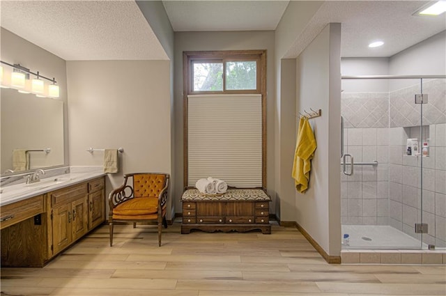 17725 W 68th Ter, Shawnee, KS 66217 - bathroom featuring wood finished floors, vanity, a shower stall, a textured ceiling, and baseboards