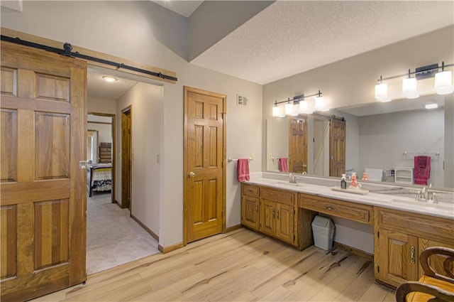 17725 W 68th Ter, Shawnee, KS 66217 - full bath with wood finished floors, double vanity, a textured ceiling, and baseboards