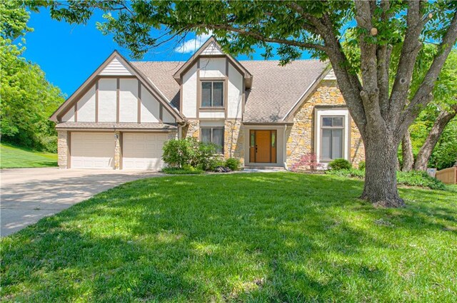 17725 W 68th Ter, Shawnee, KS 66217 - tudor-style house featuring stone siding, driveway, an attached garage, a front yard, and stucco siding