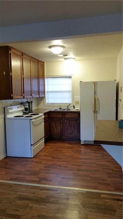 1903-05 High Grove Rd, Grandview, MO 64030 - kitchen featuring white appliances, dark wood finished floors, and a sink
