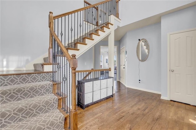 635 N Laurel St, Gardner, KS 66030 - stairs featuring wood finished floors, baseboards, and a towering ceiling