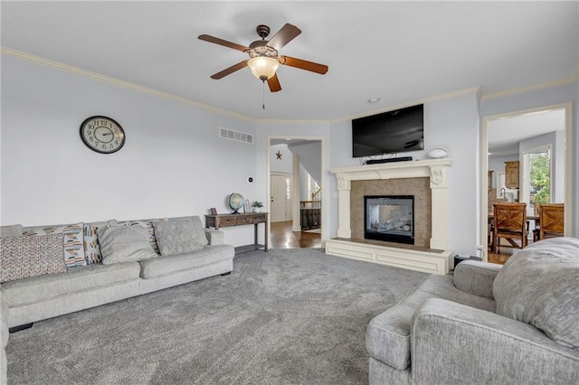 635 N Laurel St, Gardner, KS 66030 - living area featuring a glass covered fireplace, crown molding, a ceiling fan, and carpet flooring