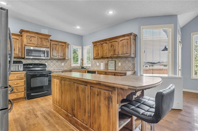 635 N Laurel St, Gardner, KS 66030 - kitchen with appliances with stainless steel finishes, a center island, light wood-style floors, plenty of natural light, and recessed lighting