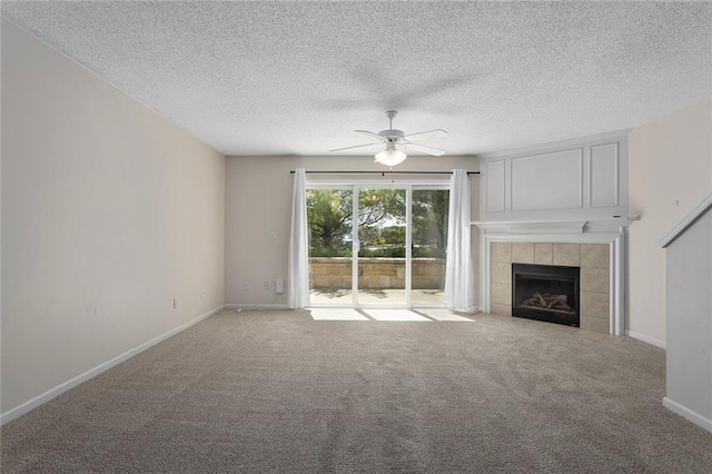 5412 Fairmount Ave, Kansas City, MO 64118 - unfurnished living room with ceiling fan, a tile fireplace, carpet floors, a textured ceiling, and baseboards