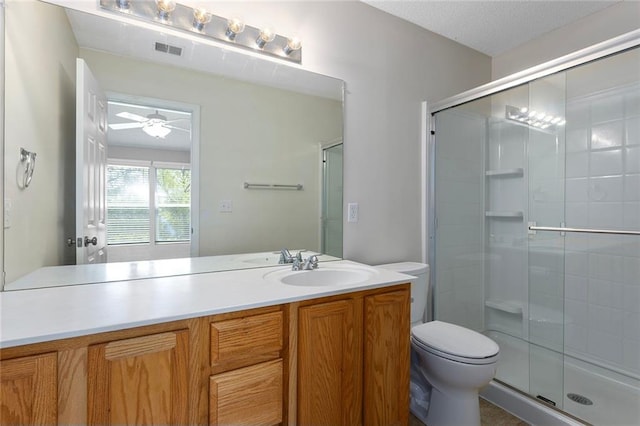 5412 Fairmount Ave, Kansas City, MO 64118 - bathroom with a stall shower, toilet, vanity, and a ceiling fan