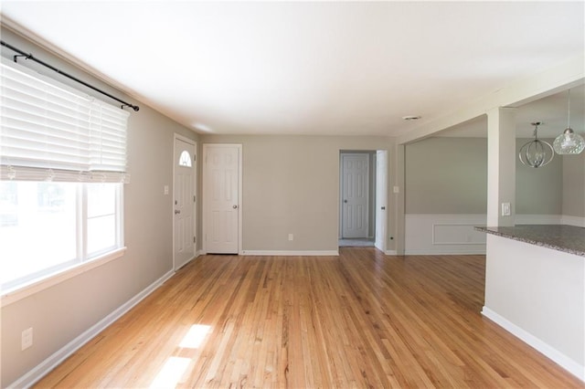 7048 Horton St, Overland Park, KS 66204 - unfurnished living room with light wood-style floors and wainscoting