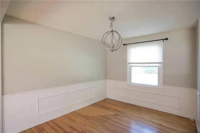 7048 Horton St, Overland Park, KS 66204 - unfurnished room featuring a chandelier, a wainscoted wall, and light wood-type flooring