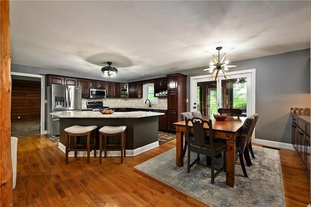 611 N Winnebago Dr, Lake Winnebago, MO 64034 - dining room featuring a chandelier, dark wood-type flooring, and baseboards