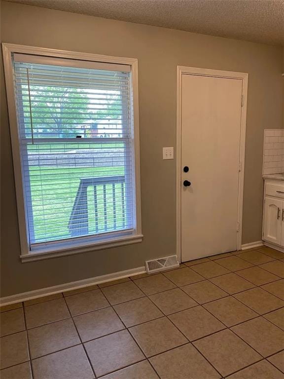 11307 W 60th St, Shawnee, KS 66203 - foyer with light tile patterned floors, plenty of natural light, baseboards, and a textured ceiling
