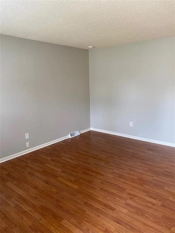 11307 W 60th St, Shawnee, KS 66203 - spare room with wood finished floors, baseboards, and a textured ceiling