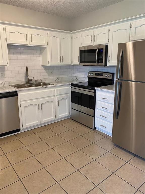 11307 W 60th St, Shawnee, KS 66203 - kitchen featuring appliances with stainless steel finishes, a sink, white cabinets, light countertops, and backsplash