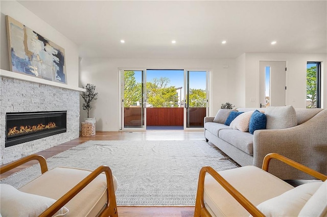 living room featuring recessed lighting, a fireplace, and wood finished floors