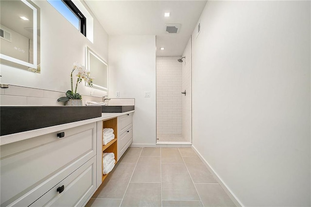 full bath with tiled shower, vanity, tile patterned flooring, baseboards, and recessed lighting