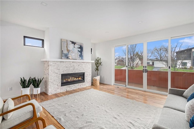 2605 W Paseo Blvd, Kansas City, MO 64108 - living area featuring a glass covered fireplace, wood finished floors, and baseboards