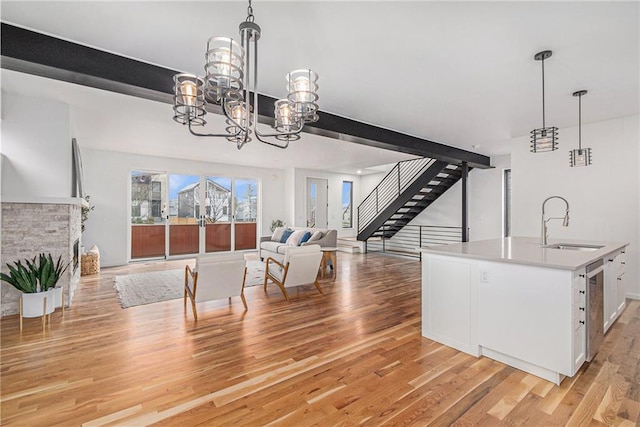 2605 W Paseo Blvd, Kansas City, MO 64108 - living area featuring a chandelier, stairs, and light wood finished floors