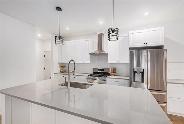 2605 W Paseo Blvd, Kansas City, MO 64108 - kitchen with wall chimney exhaust hood, stainless steel appliances, a sink, decorative backsplash, and an island with sink