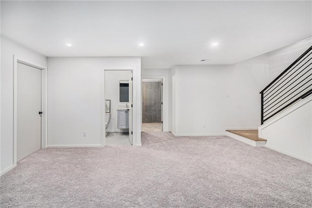 2605 W Paseo Blvd, Kansas City, MO 64108 - below grade area featuring light carpet, stairway, recessed lighting, and baseboards