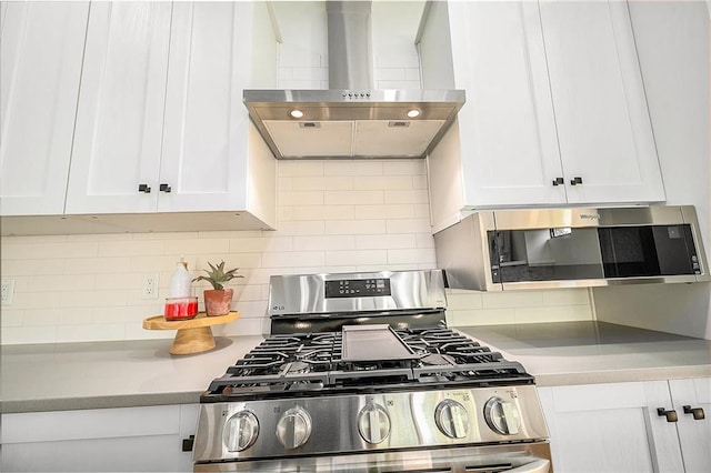 2605 W Paseo Blvd, Kansas City, MO 64108 - kitchen featuring wall chimney range hood, appliances with stainless steel finishes, white cabinets, light countertops, and decorative backsplash