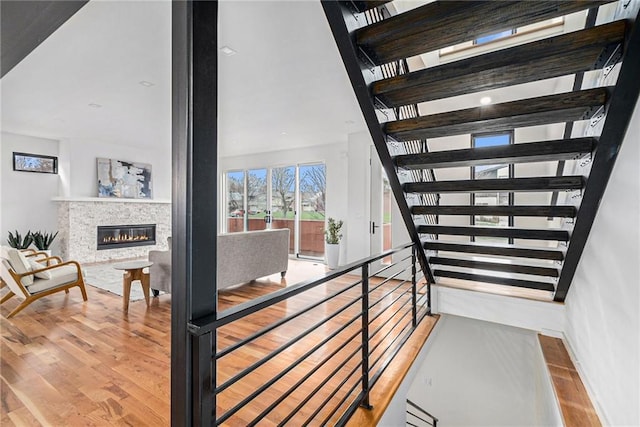 2605 W Paseo Blvd, Kansas City, MO 64108 - stairway with wood finished floors, a glass covered fireplace, and baseboards