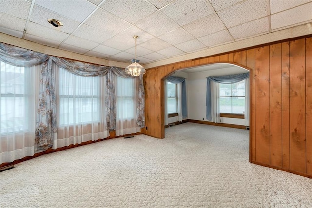 3121 Saint Joseph Ave, Saint Joseph, MO 64505 - spare room with arched walkways, carpet flooring, wood walls, baseboards, and a drop ceiling