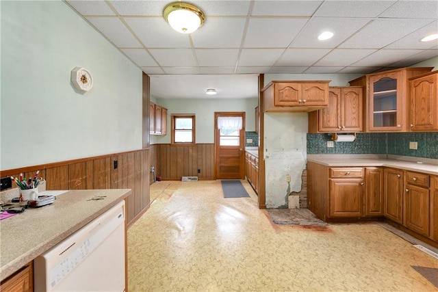 3121 Saint Joseph Ave, Saint Joseph, MO 64505 - kitchen featuring wainscoting, brown cabinets, white dishwasher, a paneled ceiling, and glass insert cabinets