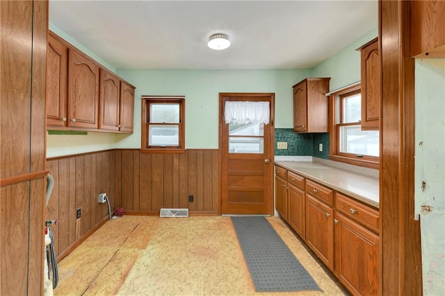 3121 Saint Joseph Ave, Saint Joseph, MO 64505 - kitchen with a wainscoted wall, brown cabinets, light countertops, and wooden walls