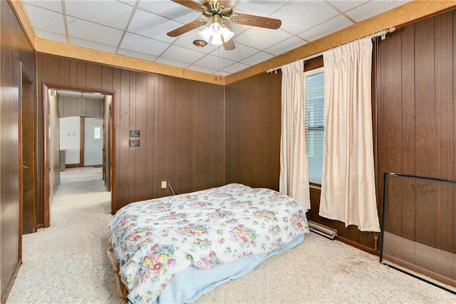 3121 Saint Joseph Ave, Saint Joseph, MO 64505 - carpeted bedroom featuring a paneled ceiling, wood walls, and ceiling fan