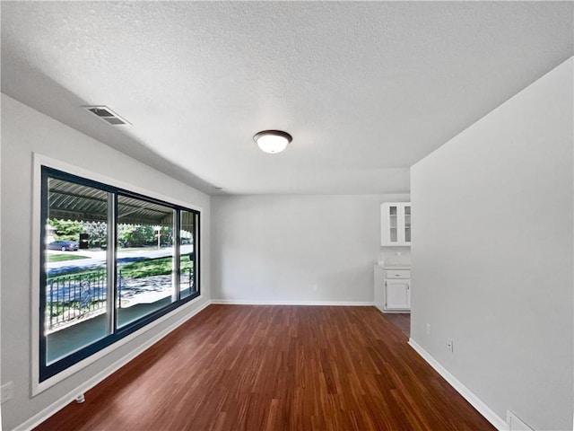 7139 Hardy St, Overland Park, KS 66204 - empty room with dark wood finished floors, baseboards, and a textured ceiling