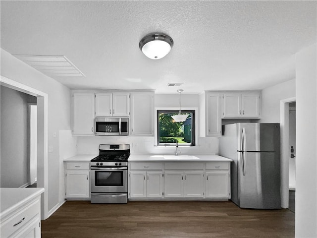 7139 Hardy St, Overland Park, KS 66204 - kitchen featuring appliances with stainless steel finishes, a sink, white cabinets, light countertops, and a textured ceiling